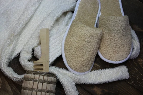 Terry roupão de banho e chinelos de banho com um pente de madeira — Fotografia de Stock
