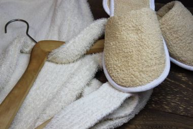 Terry bornoz ve banyo terlik ile ahşap bir askı