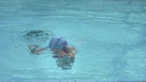 Ребенок плавает в бассейне — стоковое видео
