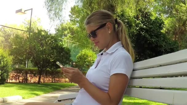 Schwangere mit Handy im Park — Stockvideo