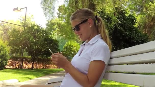 Schwangere mit Handy im Park — Stockvideo