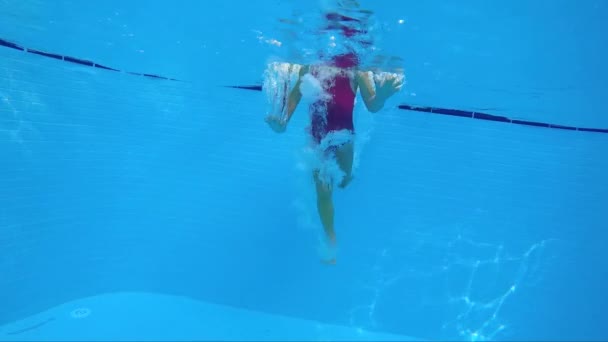 Kleines Mädchen schwimmt unter Wasser — Stockvideo