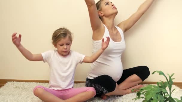 自宅でヨガの練習彼女の妊娠中のお母さんの美しい少女 — ストック動画