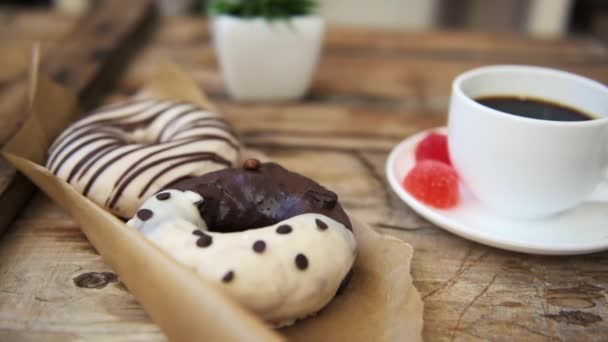 Женщина Берет Кофейную Кружку Деревянного Стола Шоколадными Пончиками — стоковое видео