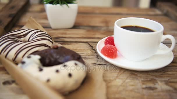 Kvinnan Tar Glaserade Donut Från Rustika Bord Med Kaffemugg — Stockvideo