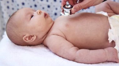 Sevimli küçük yürümeye başlayan çocuk ziyaret doktor. Çocuk doktoru dinleme yeni doğan bebek stetoskop ile.