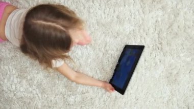 Küçük kız dijital ekran, tablet PC'de oyun oynama gösteriyordu. Çocukluk ve teknoloji.