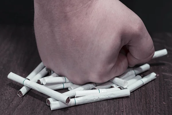 Přestat kouřit. Mans ruka leží na hromadu cigaret. — Stock fotografie