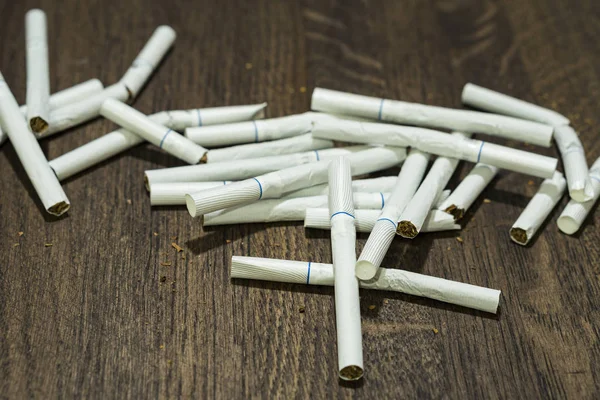 Los cigarrillos en la mesa. Rotos y enteros. Primer plano . — Foto de Stock