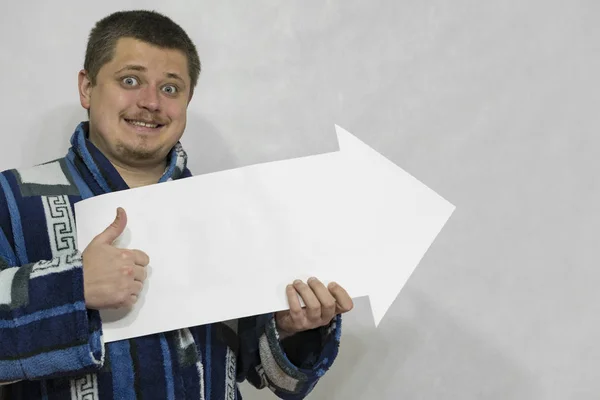 A man in gown with a white paper arrow or pointer in his hands. — Stock Photo, Image