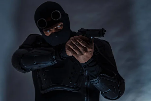 Beväpnade spion i skottsäker väst. Händerna håller en pistol. — Stockfoto