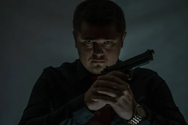 En kriminell med en pistol. Gun håller med båda händerna. Maffian. — Stockfoto