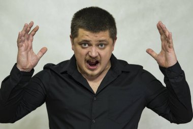 Genç adam kızgın. Eller neden oldu. Ağız açıktır. O çığlık atıyor.