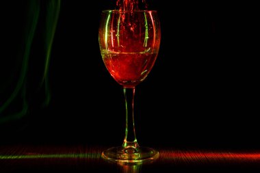 Gece kulübünde bir kadeh. Huzursuz şarap bir bardak. Işık efekti.