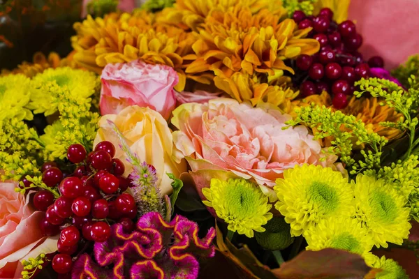 A bouquet made up of flowers and fruits. Chrysanthemum, solidago, oak leaves, rose cochlea, viburnum, cellosia.