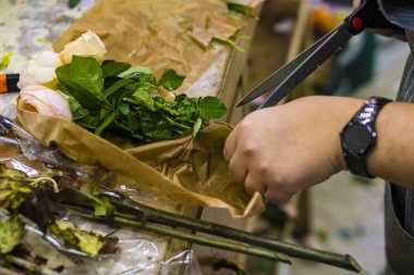 çalışan bir buket gül oluşturur. Çiçekçi stel rose keser..