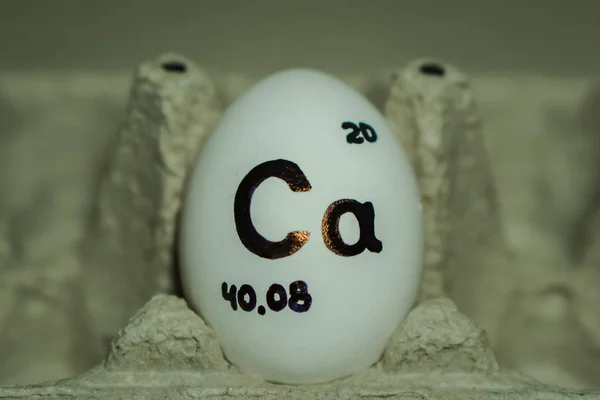 An inscription on a chicken egg for a reminder of the calcium content in it. — Stock Photo, Image