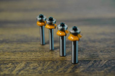 Üst üste ahşap koyu arka plan üzerinde maruz Mills. Son. Edgeband. Kesici ve yönlendirici bit freze. Köşe yuvarlak ahşap ve plastik için bit.