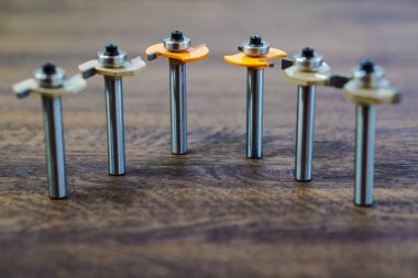 Üst üste ahşap koyu arka plan üzerinde maruz Mills. Son. Edgeband. Ahşap ve plastik kesici ve yönlendirici bit freze. Karbür matkap veya freze kesici.