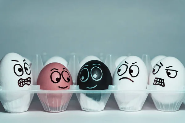 Rostros sobre huevos en forma de expresiones faciales, reflejando emociones. El concepto de racismo, malentendido, una barrera en las relaciones, la negación de la sociedad. Barreras entre personas, prejuicios . — Foto de Stock