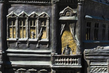 Balkonda duran bir adam. Tüccarlar evin heykel. Metal bir heykel. Bebek evi. Modeli veya Düzen insanların evlerin.