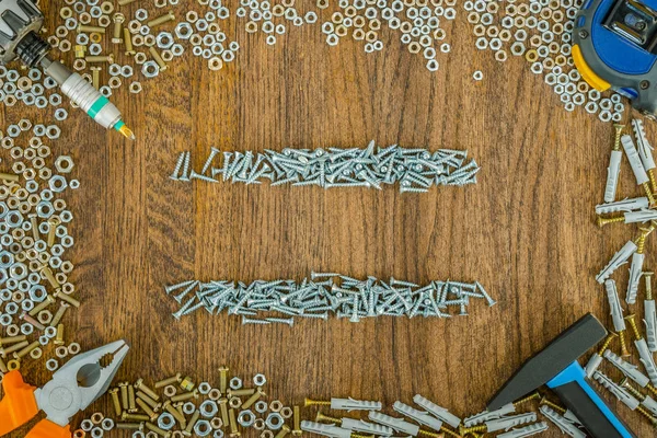 Background or background of short metal screws and nuts. Set of construction tools. — Stock fotografie