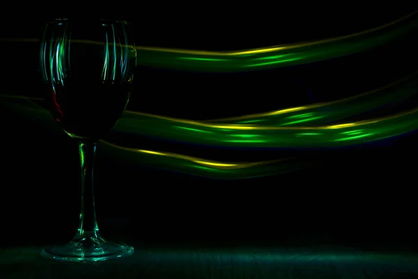 Egy pohár vörös bor, éjszakai klubban. A fényhatás. — Stock Fotó