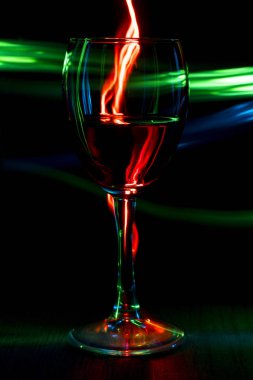 Bir bardak şarap bokeh etkisi ile parlak bir arka plan üzerinde.