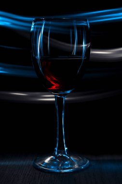 Bir bardak kırmızı şarap. Bokeh etkisi ile koyu arka plan.