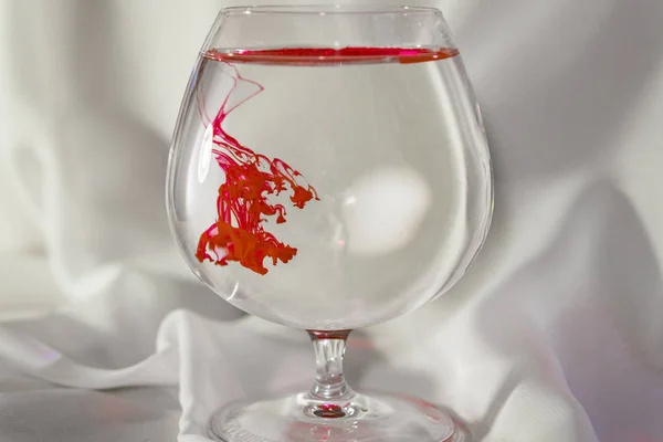 Aquarela vermelha em um copo. Mistura de cor de tinta e água. Cocktail colorido . — Fotografia de Stock