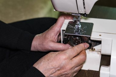 Kadının el dikiş makinesi iplik makarası değiştirmek için soket aç.