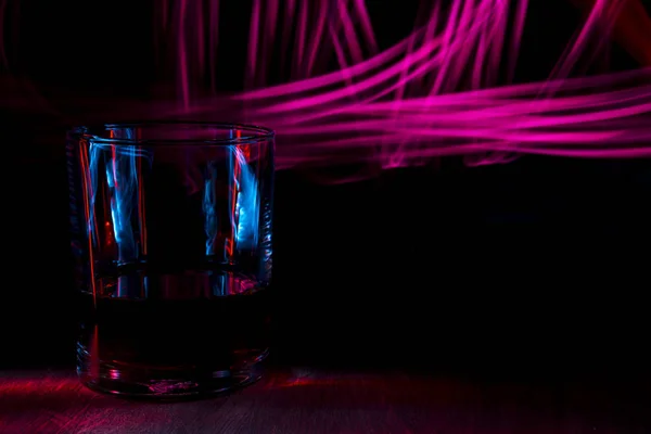 Un vaso de coñac sobre una mesa de madera . — Foto de Stock