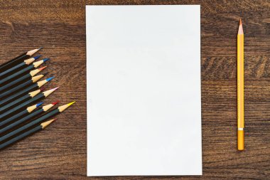 Arka plan veya arka plan kalemler üzerinde ahşap bir masa. Merkezi temiz beyaz bir levha.