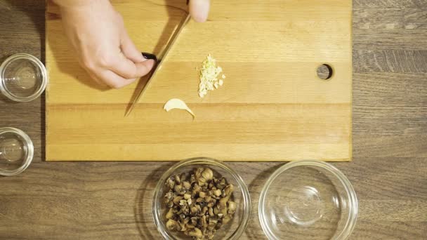 Knoblauch kochen. in der Nähe liegen geschnittene Pilze. — Stockvideo