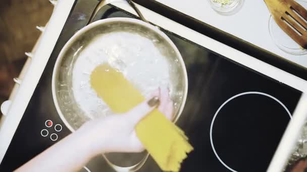 Готовьте макароны с грибным соусом. Мы опускаем вермишель в кипящую воду. . — стоковое видео