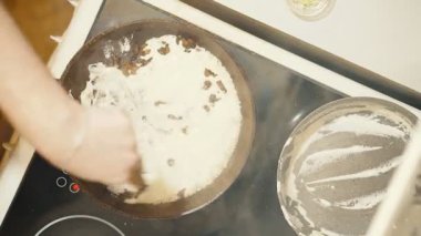 Bir elektrikli soba üzerinde tava. Mantar soslu karıştırma devam.