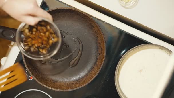 Poêle à frire sur la cuisinière. Nous avons étalé les champignons hachés . — Video