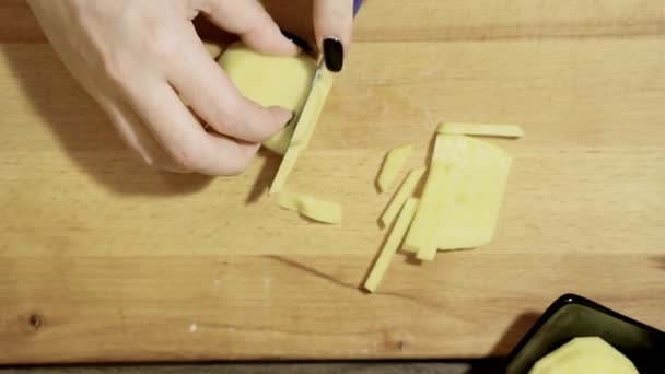 Cozinhamos batatas para fritar. Você pode cortar fatias de batata juntos . — Vídeo de Stock