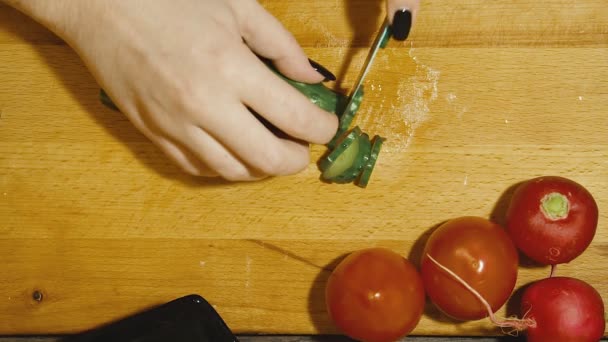 Nahaufnahme menschlicher Hände beim Kochen von Gemüsesalat in der Küche. — Stockvideo