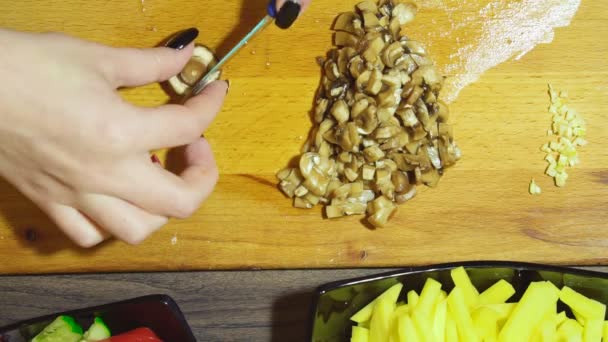 Closeup των ανθρώπινων χεριών μαγείρεμα σαλάτα λαχανικών στην κουζίνα. Κόβουμε τα μανιτάρια μερικές. — Αρχείο Βίντεο