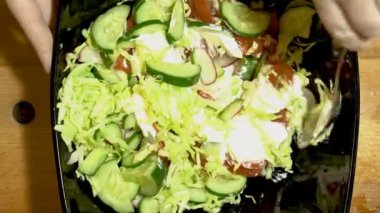 Sebze salatası hazırlanması. Bir kase lahana doğranmış sebze yayıldı. Ekşi krema ekleyin ve hafifçe karıştırın.