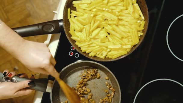 Frite os cogumelos fatiados. Batatas são fritas em uma placa elétrica nas proximidades . — Vídeo de Stock
