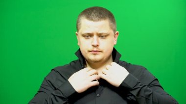 Genç adam kılığında. Yaka ve kollu gömlek düzeltir.