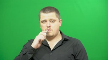 Genç bir adam elektronik sigara kullanır. Solunum güçlüğü.