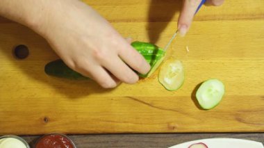 İnsan elinden yemek mutfakta sebze salata closeup. Salatalık kesme.