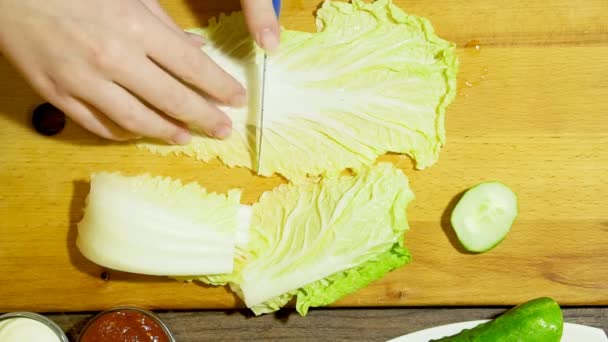 Primer plano de manos humanas cocinar ensalada de verduras en la cocina. Cortando la col todavía . — Vídeos de Stock