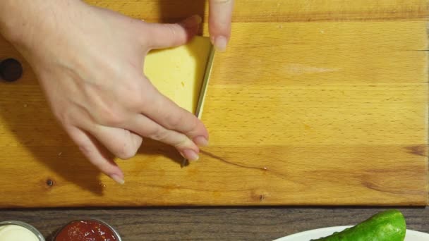 Closeup των ανθρώπινων χεριών μαγείρεμα των τροφίμων στην κουζίνα. Κοπή το τυρί. — Αρχείο Βίντεο