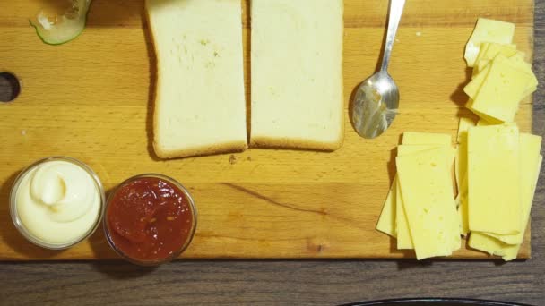 Closeup ενός ανθρώπου χέρια προετοιμασία σάντουιτς στην κουζίνα. Φέτες ψωμιού. — Αρχείο Βίντεο