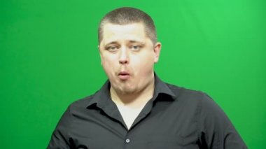 Genç adam kılığında. Çikolata yiyor. Arka plan - yeşil ekran.