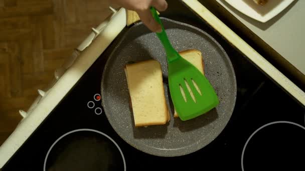 Closeup των χεριών προετοιμασία σάντουιτς στην κουζίνα. Τηγανητό δύο πρίσματα σε ένα τηγάνι. — Αρχείο Βίντεο